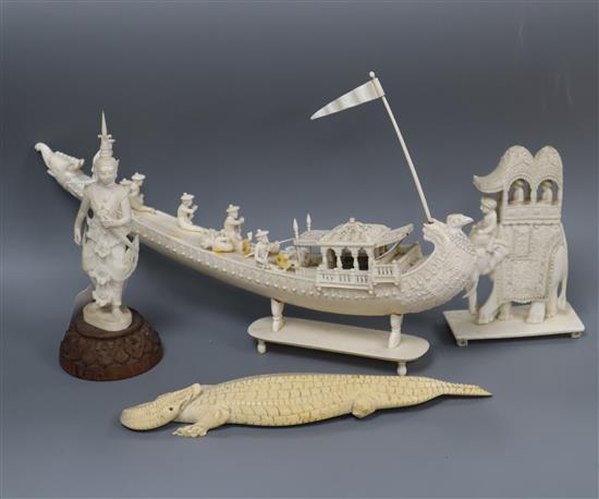 A group of Indian ivory models including a boat and a caparisoned elephant together with a Thai ivory figure and a model of a crocodile